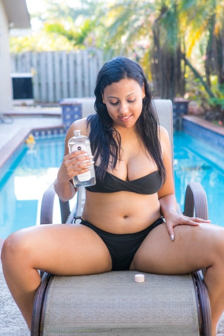 Chubby black authentic removes her bikini to pose artistic on chair by a pool