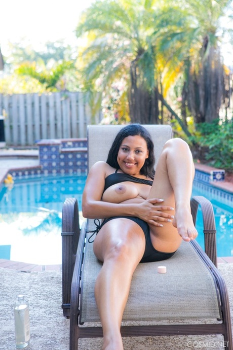 Chubby black authentic removes her bikini to pose artistic on chair by a pool