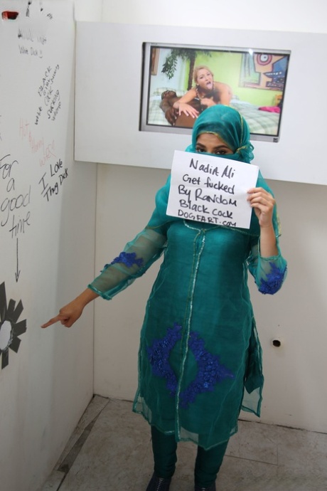 Attractive Muslim babe Nadia Ali strips at a gloryhole and sucks a huge black manhood