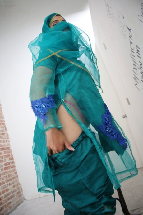 Attractive Muslim babe Nadia Ali strips at a gloryhole and sucks a huge black manhood