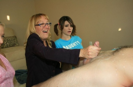 Mature blonde in glasses teaching her young adult friends how to stroke a big manhood
