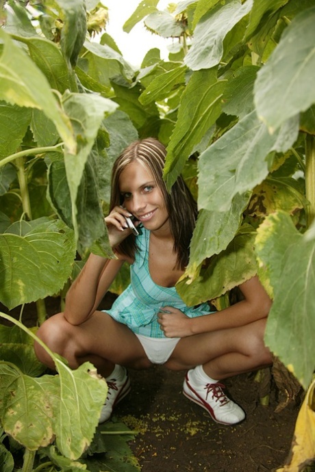 Cute authentic girl toys her teem femininity on a blanket among the foliage
