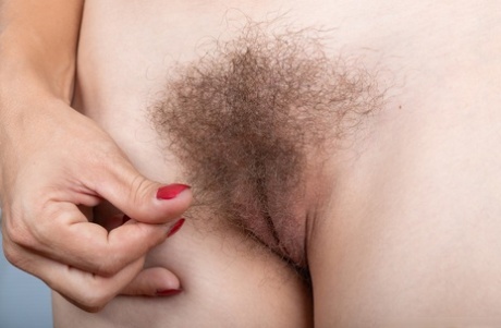 Authentic girl Bridgette Aleister spreads her hairy muff while sporting red lips