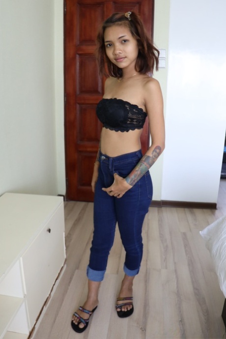 Pretty Asian girl Emelyn shows off her petite body while undressing for intimacy