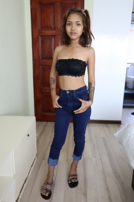 Pretty Asian girl Emelyn shows off her petite body while undressing for intimacy