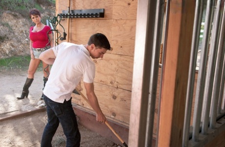 Attractive granny Gina Milano seduces the ranchhand in cowgirl boots and jean shorts