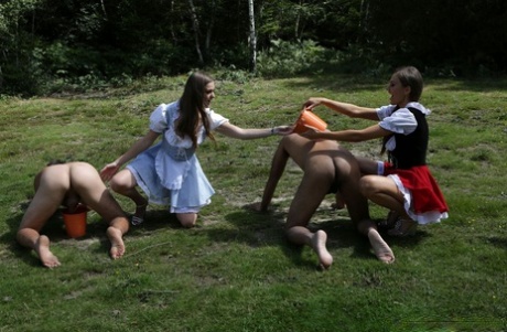 Horny femdom girls in costume head to the field to milk their natural man slave