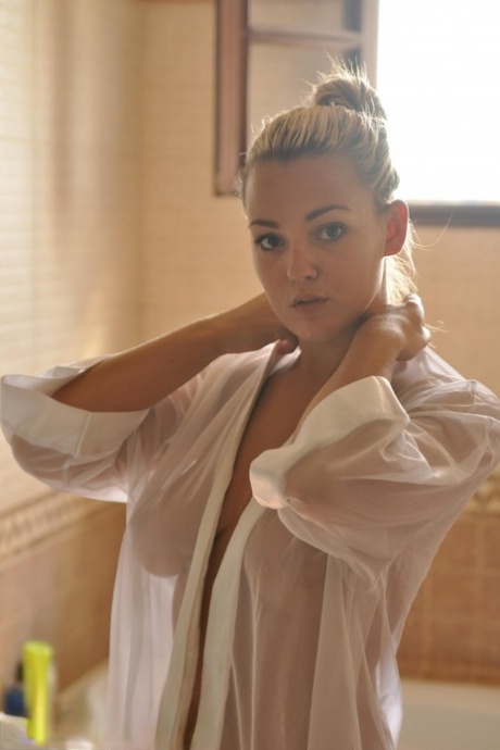 Beautiful blonde chick Jodie Gasson pulls on a see thru blouse in the morning
