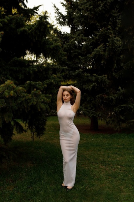 Beautiful braless authentic babe with big breasts posing in her white dress outside