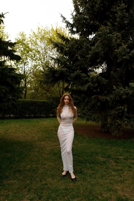 Beautiful braless authentic babe with big breasts posing in her white dress outside