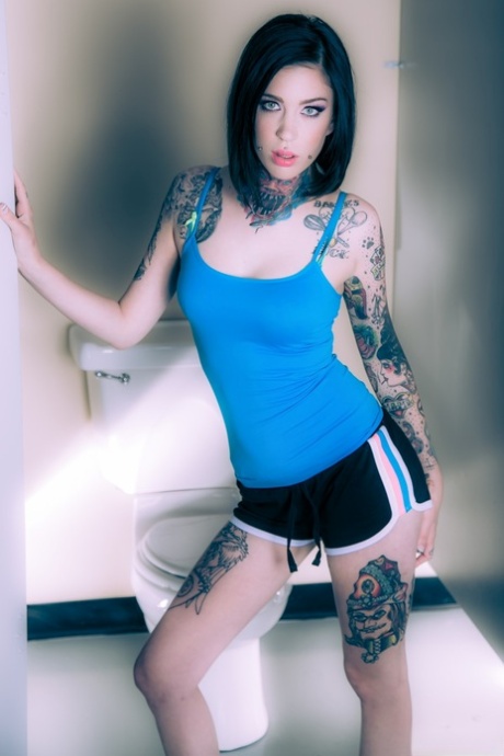 Brunette tattoo model revealing tiny breasts and tight curves before masturbating