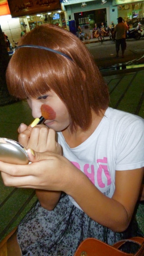 Red-haired Asian ladyboy lifts dress up to flash manhood in public place