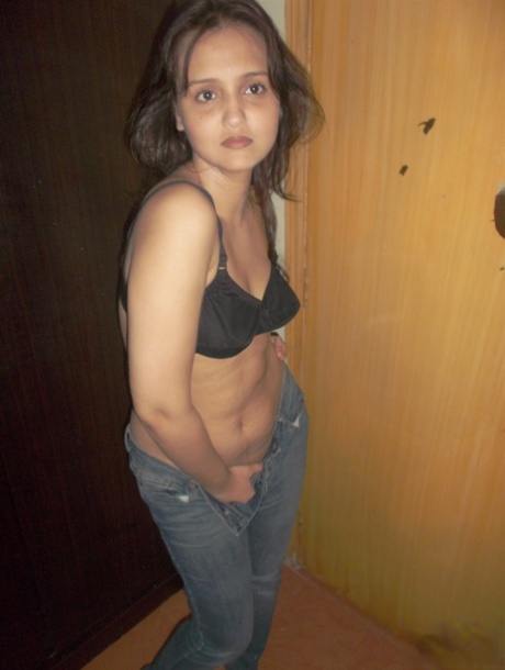 Attractive Indian model in tight jeans posing seductively in alluring lace bra
