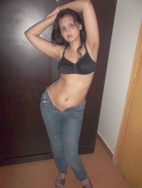 Attractive Indian model in tight jeans posing seductively in alluring lace bra