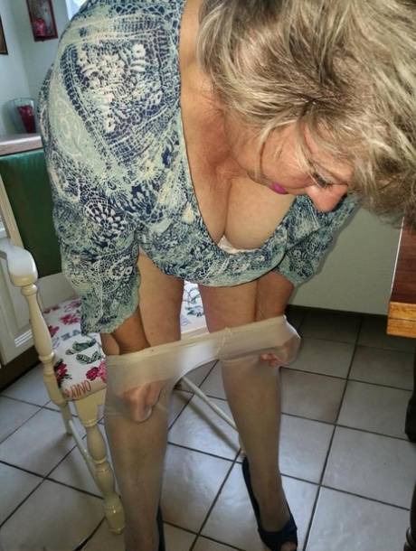 Horny granny Caro sticks a banana inside her natural femininity on kitchen chair