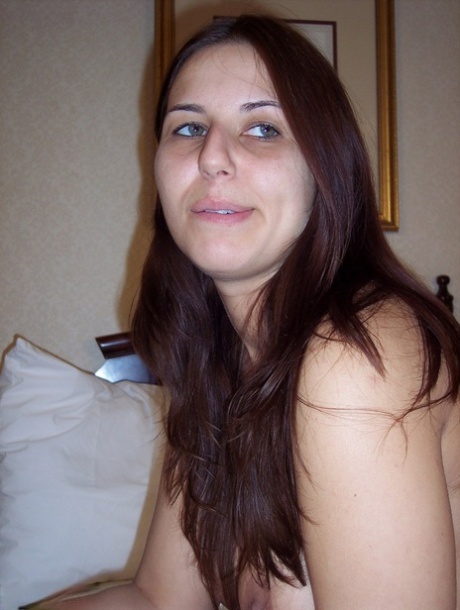 Totally natural girl Lexxxi sits on her bed while smoking a cigarette