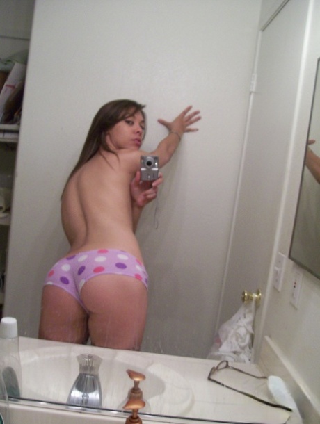 Authentic young adult shows off her fine curves in panties while taking artistic photos