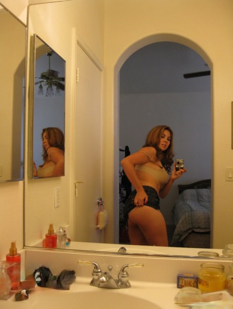 Redheaded chick Mai unveils her big breasts while going artistic in a mirror