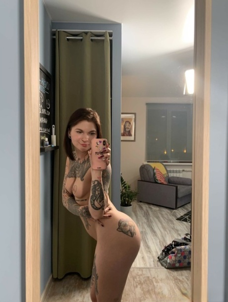 Tattooed babe shows off her small breasts & her big curves while taking artistic selfies