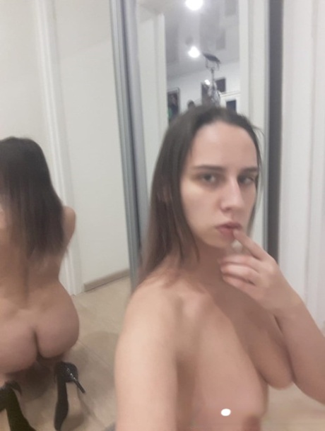 Naughty authentic babe poses natural in the mirror and shows her juicy breasts