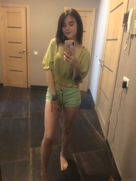 Slender amateur brunette strips and poses naked in front of the mirror