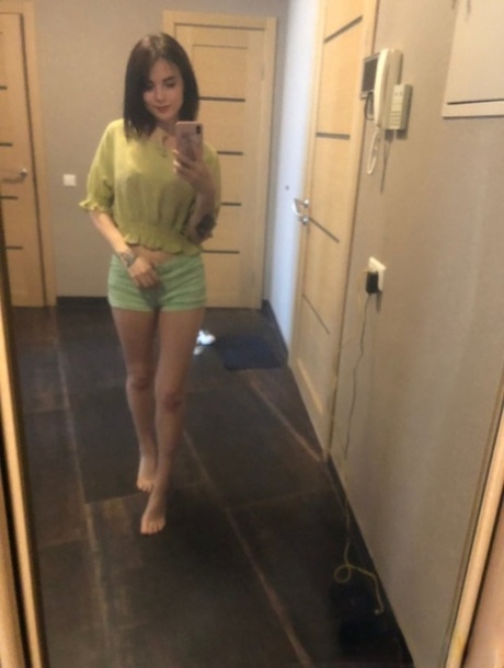 Slender amateur brunette strips and poses naked in front of the mirror