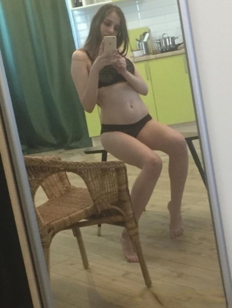 Dark-haired honey poses naked and in her sexy lingerie in the mirror