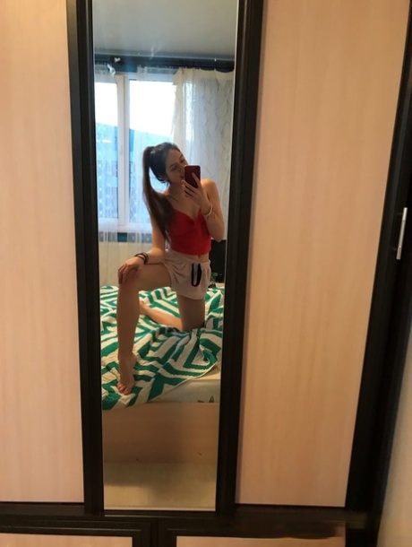 Amateur honey with small tits posing naked in front of a mirror