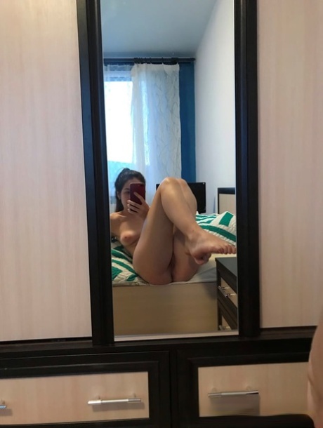 Amateur honey with small tits posing naked in front of a mirror