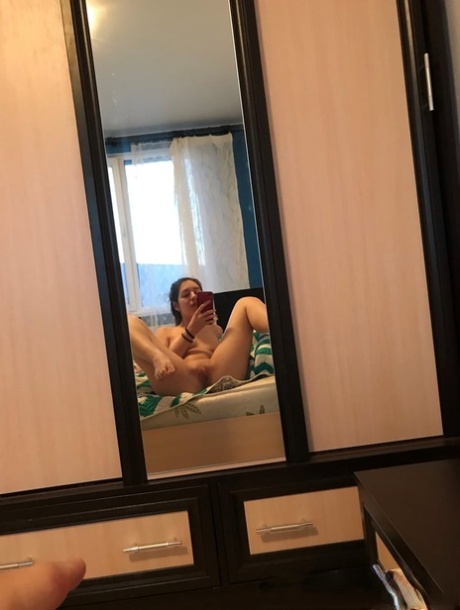 Amateur honey with small tits posing naked in front of a mirror