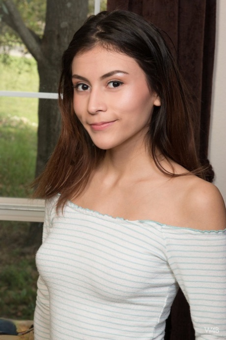 Young brunette Amelia Pearl holds her face firm while petting her bald femininity