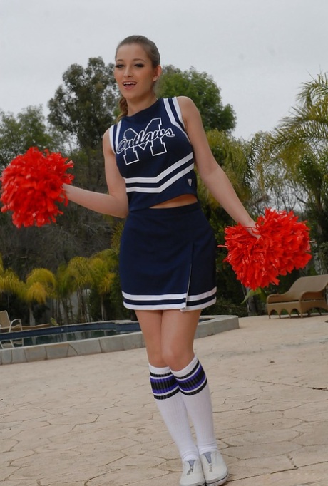 Young adult cheerleader Dani Daniels pulls up her skirt to toy her gloryhole